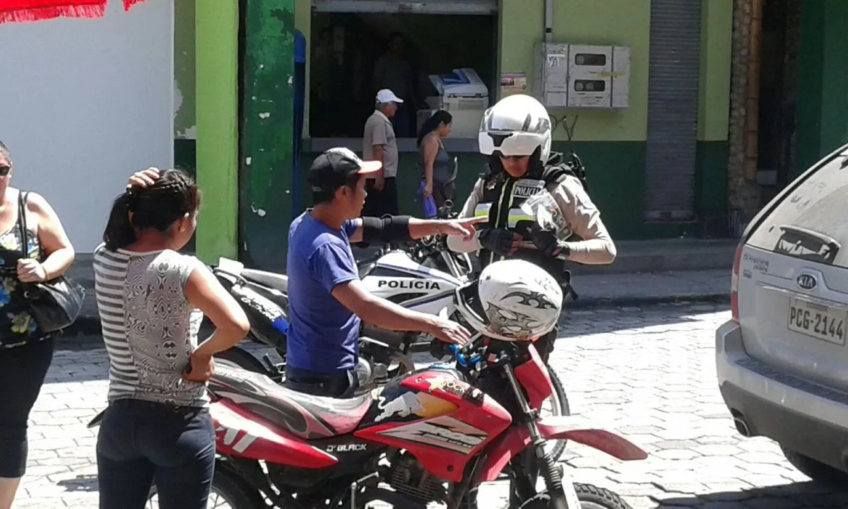 El uniformado revisaba los documentos del conductor de la moto
